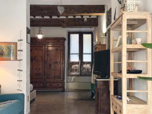 a living room with a tv and a wooden door at Casa dell'Artista - HelloElba in Portoferraio