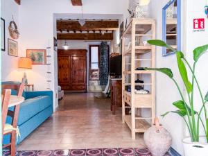 a living room with a blue couch and wooden shelves at Casa dell'Artista - HelloElba in Portoferraio