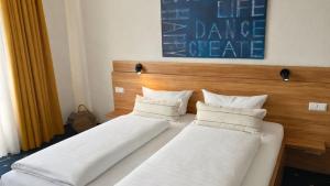 two beds with white pillows in a room at Hotel Capri in Überlingen +26 photos