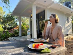 a woman sitting at a table drinking a bottle of wine at Willow Waters in Galle