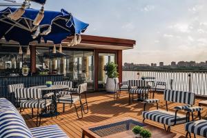 a patio with tables and chairs on a deck at Mazaj Meroot Dahabiya - Every Monday from Luxor in Luxor +10 photos
