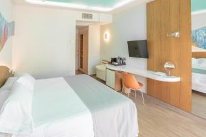a hotel room with a bed and a desk and a tv at Hotel LIVVO Puerto de Mogán in Puerto de Mogán +41 photos