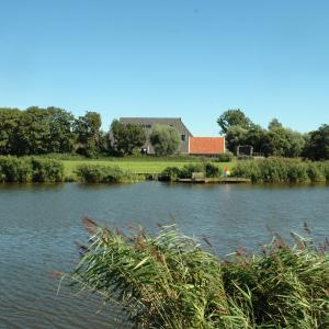 a house sitting on the side of a lake at Gastopstal in Wyns