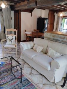 a living room with a white couch and a table at Le petit Moulin de Drée in Drée