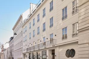 a large white building with balconies on a street at Miiro Spittelberg NEW OPENING in Vienna