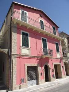 - un bâtiment rose avec une porte et un balcon dans l'établissement Un viaggio nel tempo, à Tortoreto Lido