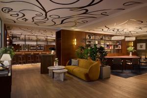 a lobby with a yellow couch and a bar at Miiro Spittelberg NEW OPENING in Vienna