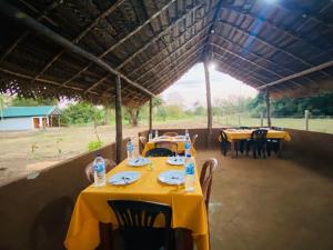 a table with yellow table cloths and bottles of water at Villu Trails Wilpattu in Wilpattu