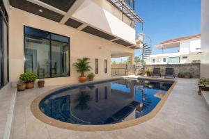 a swimming pool in the backyard of a house at Rawai 3BR Villa Shared Pool near Shops & Dining in Ban Saiyuan (1)