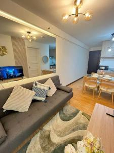 ein Wohnzimmer mit Sofa und ein Esszimmer in der Unterkunft Js Place at Arezzo Place Davao in Davao City