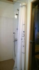a shower with a white shower curtain in a bathroom at Villa Vuorenpää in Tammela +70 photos