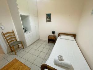 a small bedroom with two beds and a chair at Eleni's Cottage in Fiskardo