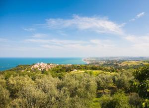 a view of a house on a hill next to the ocean at La Terrazza del Conero La Ginestra in Sirolo +3 photos