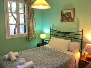 a bedroom with a bed and a window and two towels at Eleni's Cottage in Fiskardo