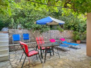 a table and chairs with an umbrella and a table and chairs at Eleni's Cottage in Fiskardo +3 photos