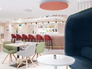 a restaurant with tables and chairs and a bar at Novotel Suites Montpellier Antigone in Montpellier