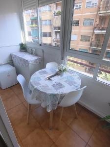 a white table and chairs in a room with windows at Donatella Guesthouse Alicante in Alicante