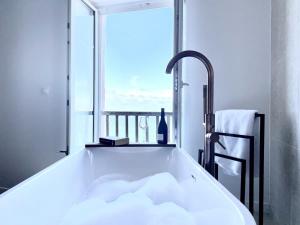 a bath tub in a bathroom with a window at ILE CEZON - Duplex de luxe avec magnifique vue mer in Landéda