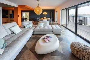a living room with a large couch and a table at ILE CEZON - Duplex de luxe avec magnifique vue mer in Landéda