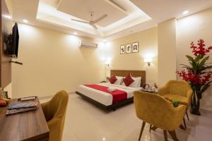 a hotel room with a bed and a table and chairs at Hotel Ganga Ashoka-Stay By The Ganges At Triveni Ghat in Rishīkesh
