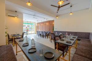 a restaurant with tables and chairs in a room at Hotel Ganga Ashoka-Stay By The Ganges At Triveni Ghat in Rishīkesh