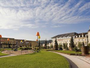 a park with benches in front of a building at Mercure Périgueux Centre Historique in Périgueux