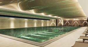 a swimming pool in a building with chairs at Doubletree By Hilton Afyonkarahisar in Afyon