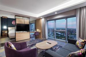 a living room with a couch and a tv and a bedroom at Doubletree By Hilton Afyonkarahisar in Afyon
