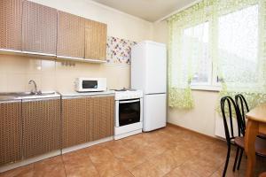 モスクワにあるApartLux Babushkinskayaのキッチン(白い冷蔵庫、テーブル付)