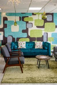 a living room with a blue couch and a table at The Bethesdan Hotel, Tapestry Collection by Hilton in Bethesda