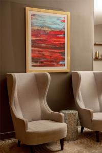 two chairs in a room with a painting on the wall at The Bethesdan Hotel, Tapestry Collection by Hilton in Bethesda