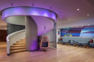a spiral staircase in a lobby with a purple ceiling at The Bethesdan Hotel, Tapestry Collection by Hilton in Bethesda