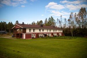 a large house with a green field in front of it at Quiet Nature Studio in Lahemaa, Garden, Terrace and pet friendly in Kolga