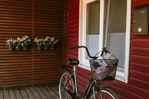 a bike parked next to a red house with flowers at Quiet Nature Studio in Lahemaa, Garden, Terrace and pet friendly in Kolga
