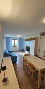 a living room with a table and a blue couch at Appartamenti Vista Lago - Costermano sul Garda - Be Happy! in Costermano sul garda