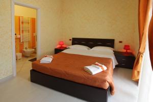 een slaapkamer met een groot bed en 2 handdoeken bij Number60 in Fiumicino