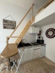 a kitchen with a wooden staircase in a room at Les Capucins de Provins Studio in Provins