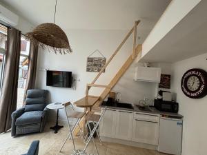 a living room with a kitchen with a staircase on the wall at Les Capucins de Provins Studio in Provins