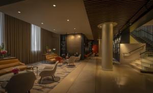 a lobby with chairs and tables and a staircase at The Morrison Dublin, Curio Collection by Hilton in Dublin