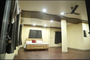 a bedroom with a bed and a ceiling fan at Royal Resort in Indore