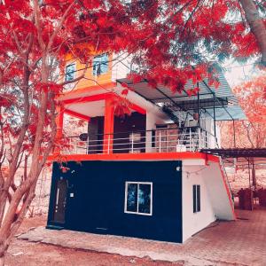 a blue and white house with a tree at Royal Resort in Indore
