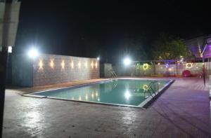 an empty swimming pool at night with lights at Royal Resort in Indore