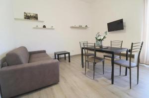 a living room with a couch and a table with chairs at Pompei Centro Apartments in Pompei