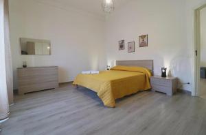 a bedroom with a bed with a yellow bedspread on it at Pompei Centro Apartments in Pompei