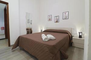 a bedroom with a bed with two towels on it at Pompei Centro Apartments in Pompei