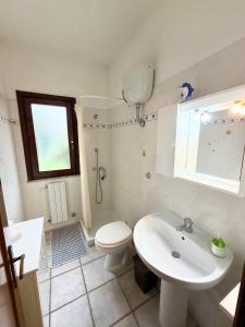 a white bathroom with a toilet and a sink at Casa vacanza Oleandro in San Teodoro