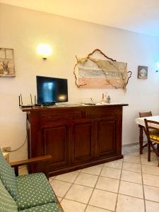 a living room with a tv on top of a cabinet at Casa vacanza Oleandro in San Teodoro