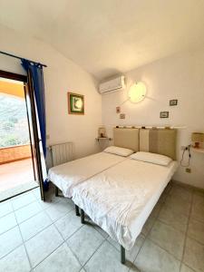 a bedroom with a bed and a large window at Casa vacanza Oleandro in San Teodoro