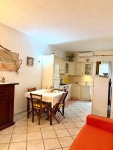 a kitchen with a table and chairs and a refrigerator at Casa vacanza Oleandro in San Teodoro +10 photos