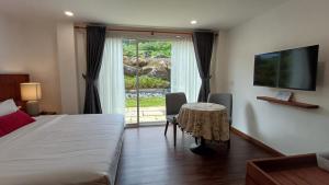 a bedroom with a bed and a table and a window at Sling & Stone Mountain Suites - Heritage House in Kampong Kundassan +106 photos